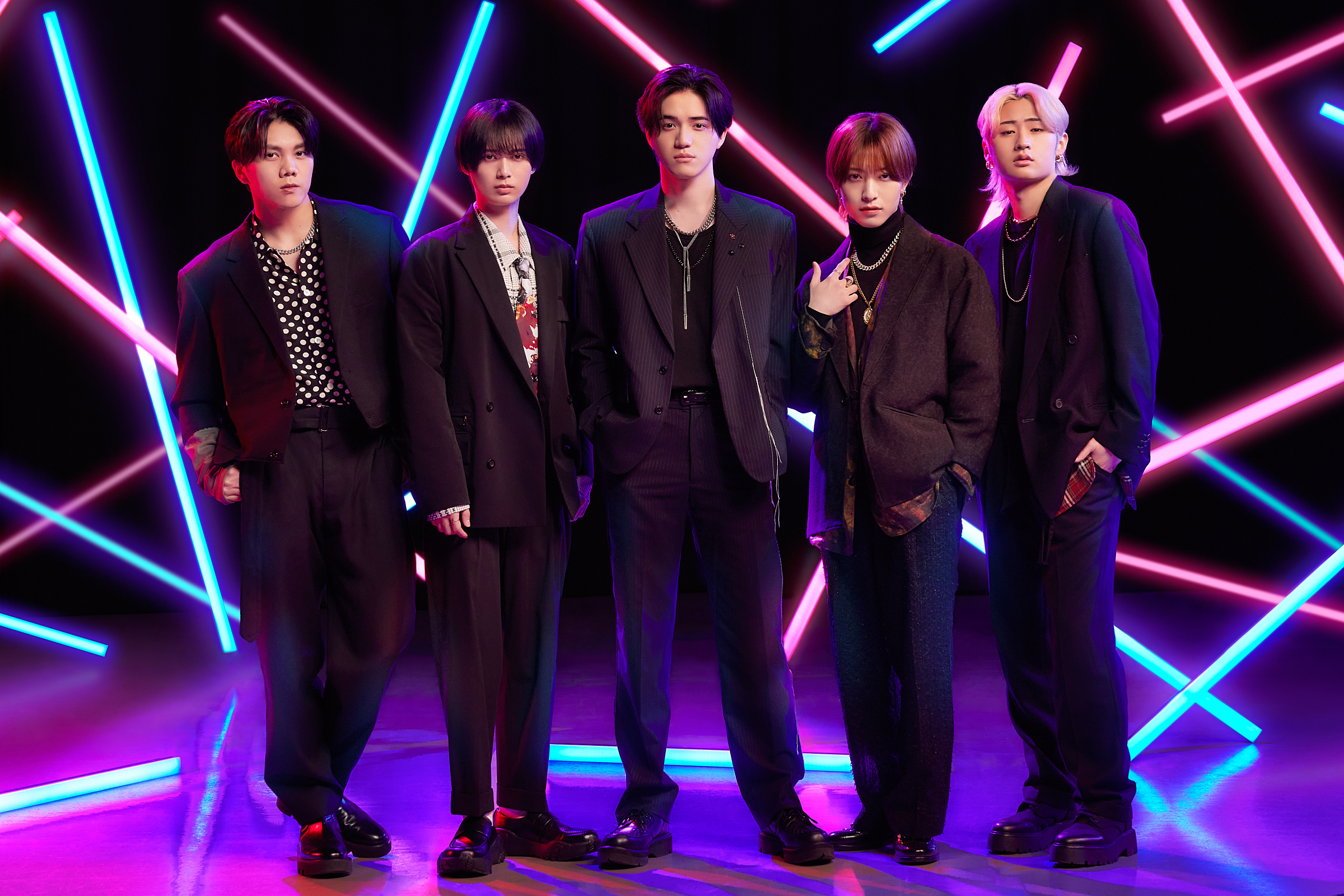 A five-member idol group, KEY TO LIT, poses stylishly against a backdrop of colorful neon lights. Each member showcases their unique fashion, representing the group's vibrant energy and charisma.