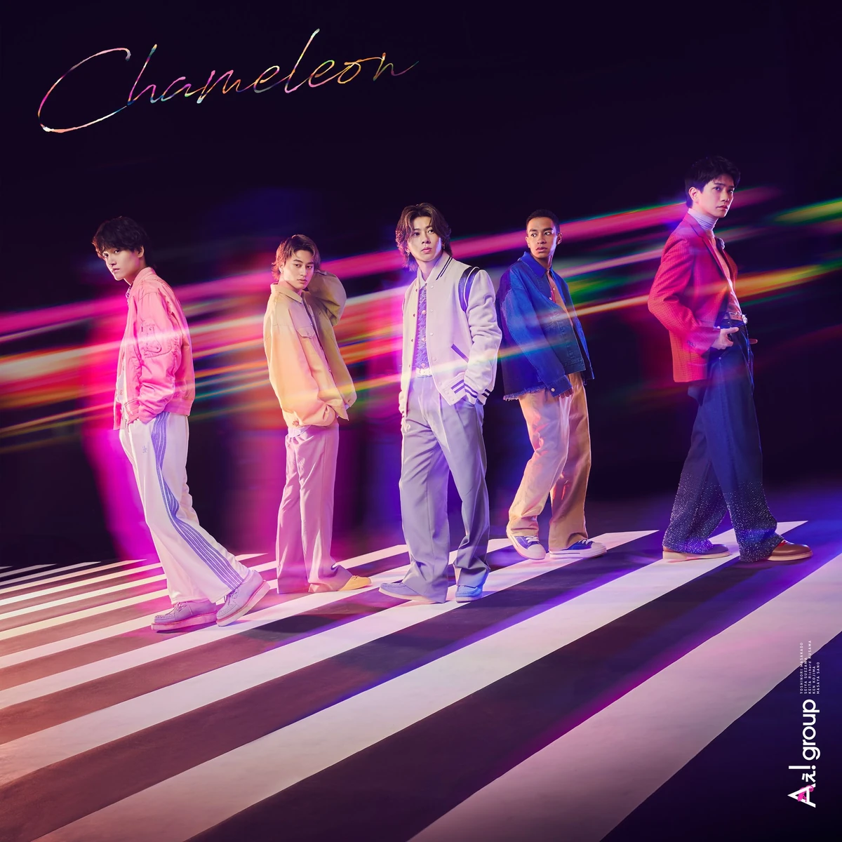 A dynamic group photo of **Ae! group**, featuring five members walking confidently across a black and white striped floor, with colorful streaks of light in the background. Each member is dressed in stylish, vibrant outfits that reflect their individuality.