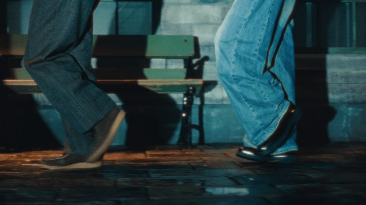 Close-up shot of Kaito and Ren's feet wearing stylish shoes, dancing on a cobblestone street under warm lighting, evoking a classic cinematic atmosphere.