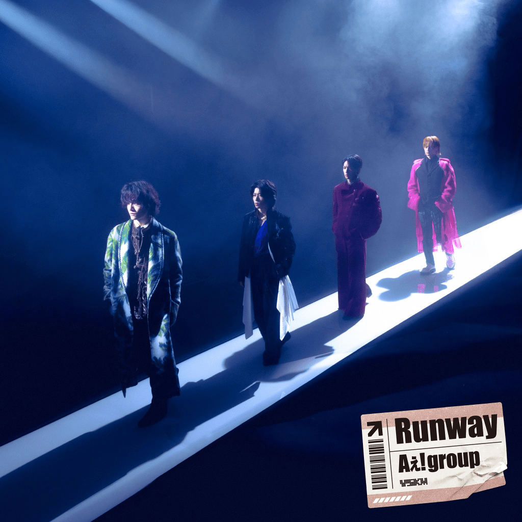 Four members of Ae! group walking down a brightly lit runway, surrounded by a misty atmosphere, under dramatic lighting.