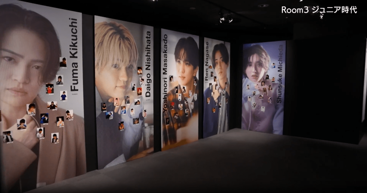 A gallery space featuring large portraits of Juniors Fuma Kikuchi, Daigo Nishihata, Yoshinori Masakado, Ren Nagase, and Shunsuke Michieda, surrounded by smaller photographs pinned on the walls.
