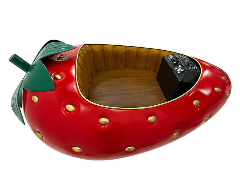 A large, whimsical strawberry-shaped boat with a wooden interior and a control panel on one side.