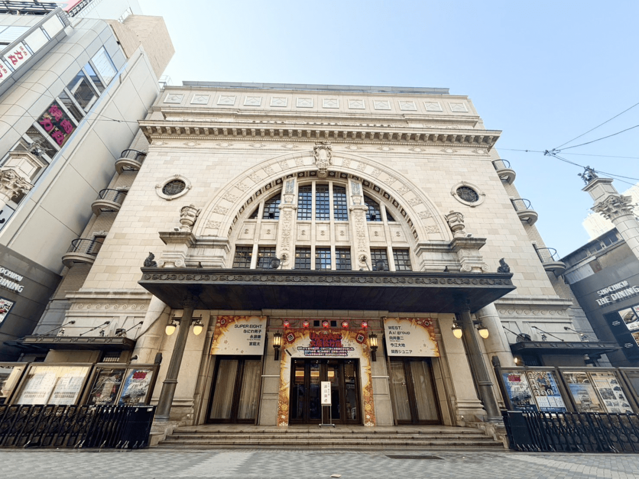 Facade of an ornate building with elaborate architectural details, featuring a large entrance and decorative signage.