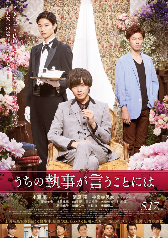 A movie poster featuring three young men in formal attire, with a luxurious background adorned with flowers and curtains. One man sits in an elegant chair holding a glass, while another stands with a serving tray, and a third man stands to the side, creating a dramatic contrast.
