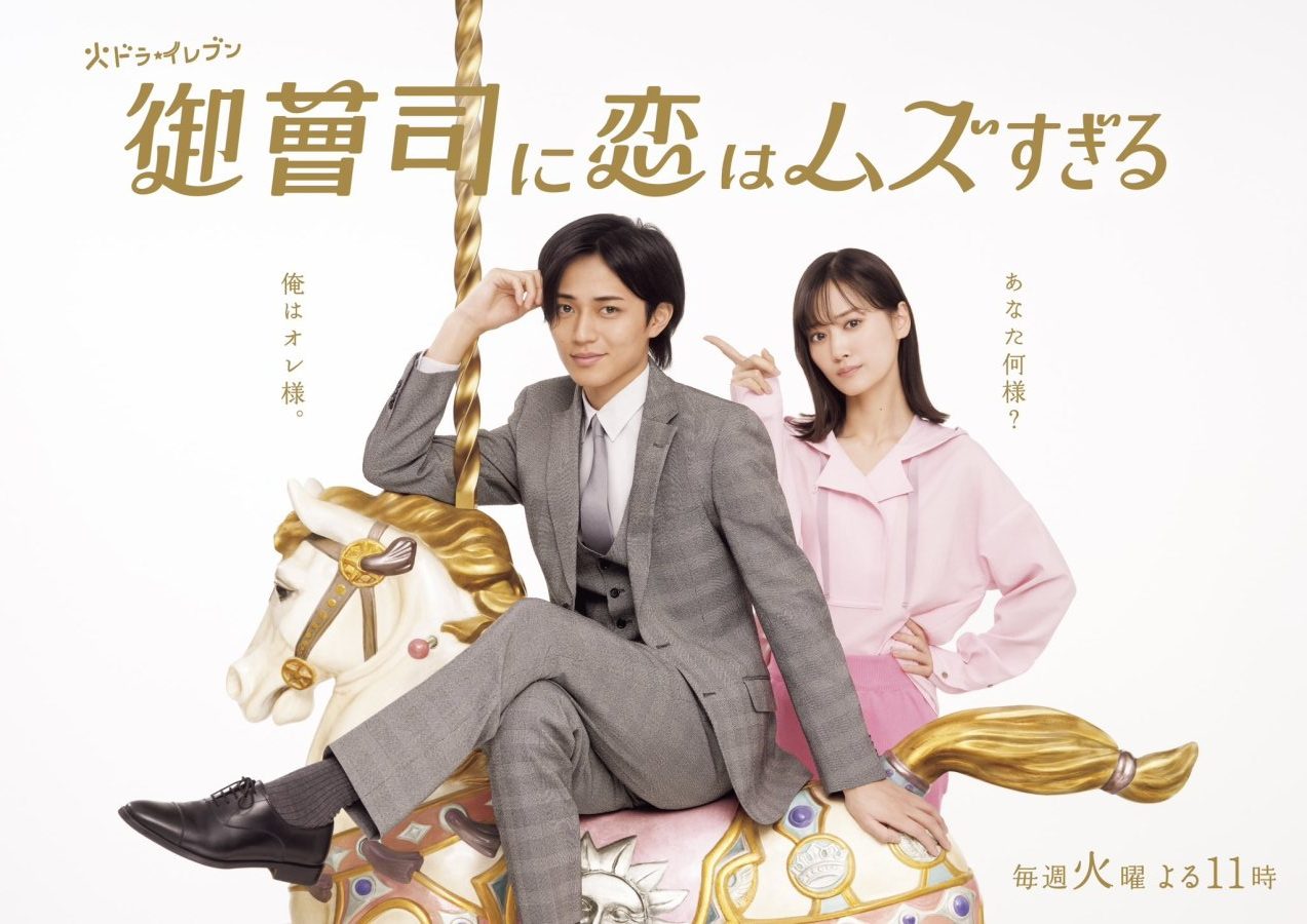 A promotional image for a Japanese drama featuring a man in a grey suit sitting on a carousel horse, with a woman in a pink outfit posing next to him.