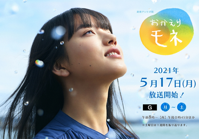 A young woman gazes upwards with a serene expression, surrounded by a blue sky and water droplets, promoting a television show with the title 'おかえり モネ' and details about its airing schedule.