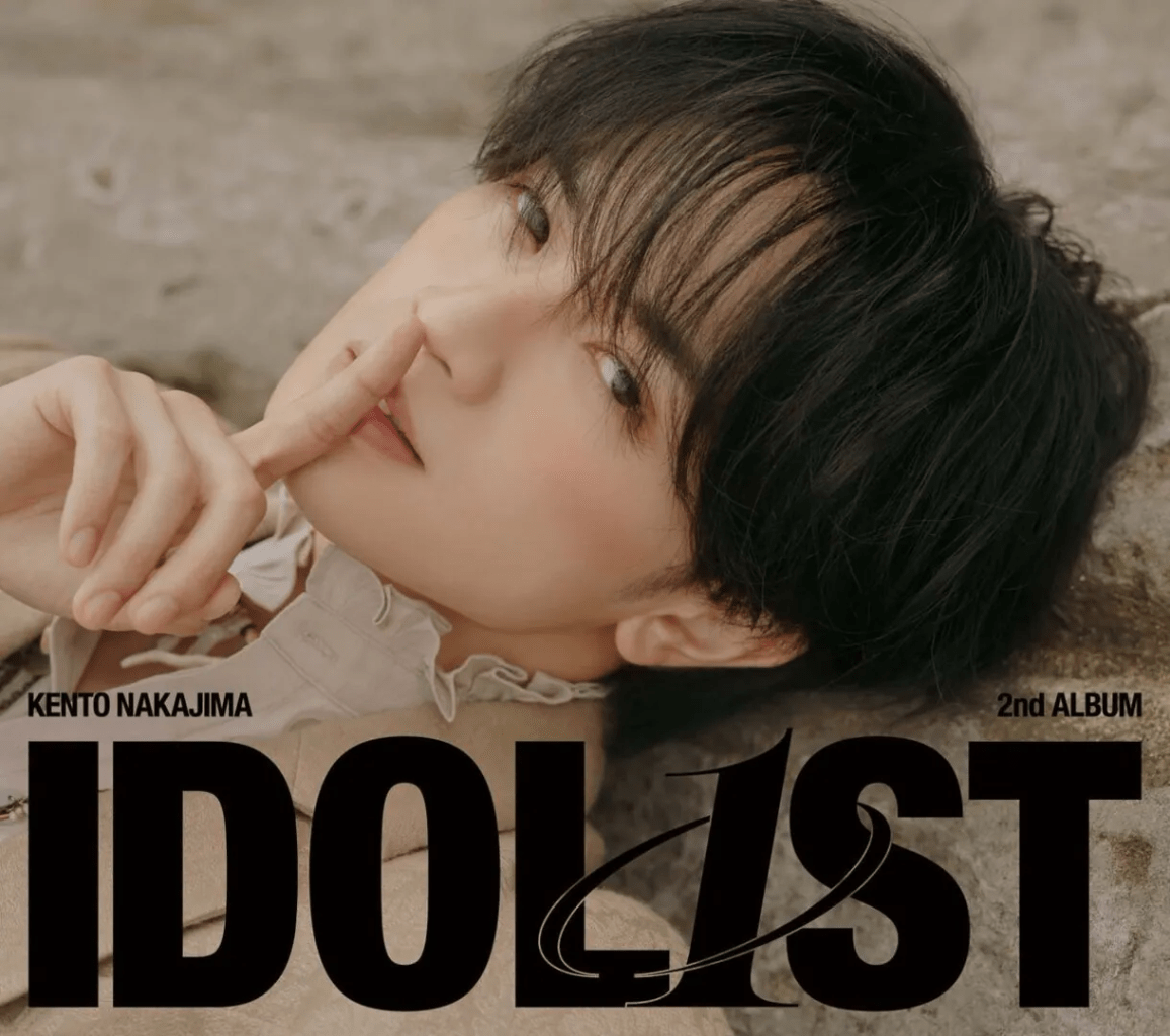 Portrait of a young man with dark hair, finger on his lips in a shushing gesture, featuring the text 'IDOLIST' and '2nd ALBUM' overlaid.